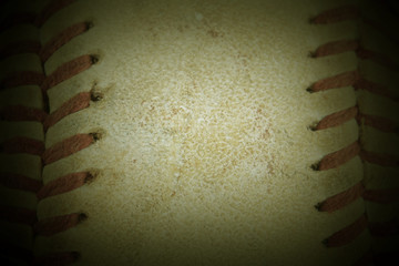 Macro image of the laced seams of a weathered and beaten old baseball. Sports background. Strong vignette. Copy space