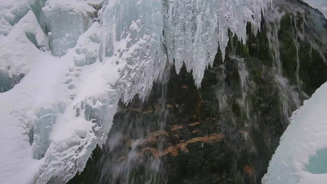 Sliding fottage of a waterfall in the winter with icicles