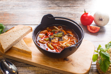 Hot goulash soup in a black pot