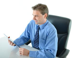 Business man at his desk working and reading a tablet