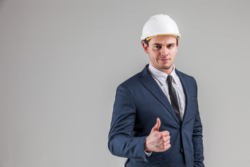 Portrait of a businessman in white helmet on gray background