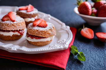 Mini Victoria sponge cakes with whipped cream and strawberries