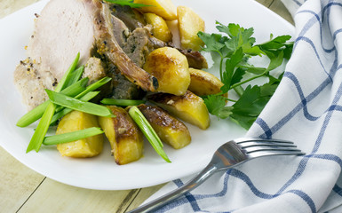 Roast pork with potato wedges and vegetables