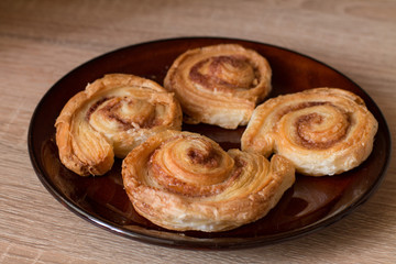Obraz na płótnie Canvas Cinnamon rolls buns on plate on wood.