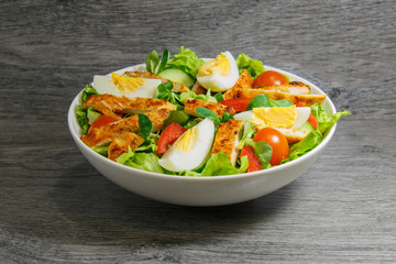 Grilled chicken salad with lettuce, tomatoes and eggs