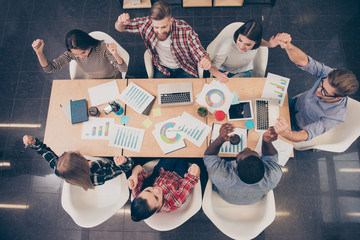 Top view of young happy multinational colleagues achived financi