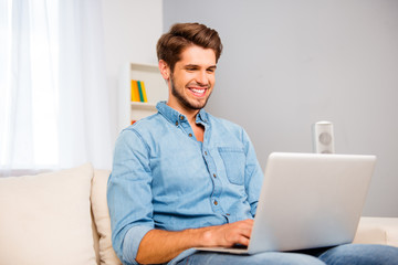 Portrait of young happy freelancer working on laptop at home