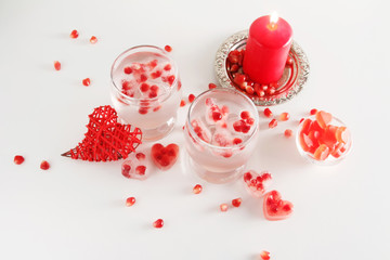 Romantic still life. Two glasses with alcoholic cocktail and ice, decorated with pomegranate, red...
