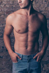 Fototapeta premium Close up of strong young bodybuilder on brick wall background