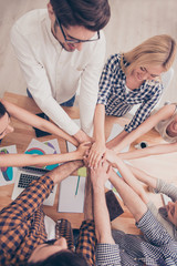 Obraz premium Top view of group of young people holding hands together