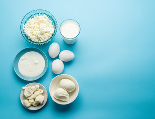 Obraz na płótnie Canvas Protein products: cheese, cream, milk, eggs on the blue backgrou