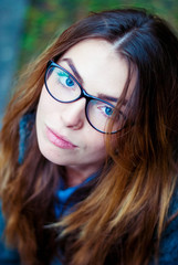 Sad beautiful girl in glasses with blue eyes.