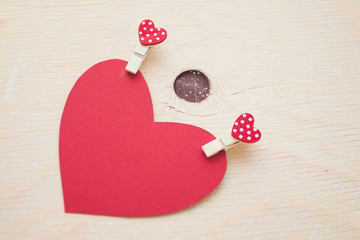 Red paper heart with pins on a wood table