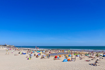 People sunbathing on Atlantic beach in Carcavelos, Portugal