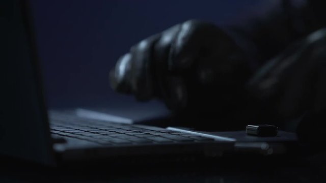 Hands of criminal stealing information from computer, copying files to USB drive