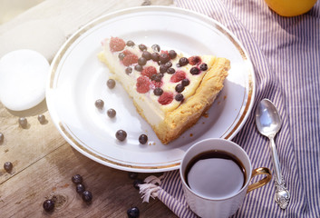 Sunny Photo with a morning breakfast in a rustic style. Cheesecake with raspberries and blueberries on wooden table. Selective focus picture