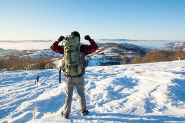 Backpacker hiking on snow covered mountain