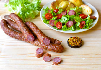 Sausage with vegateble salad on a wooden board