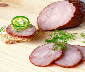 Smoked sausage with herbs on a wooden board
