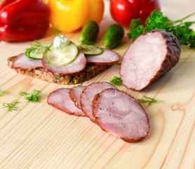 Smoked sausage with herbs on a wooden board