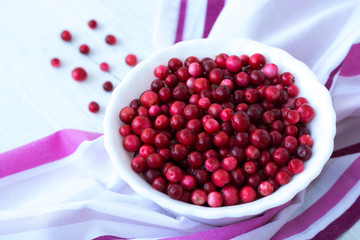 Red cranberry and white plate on pink napkin close up