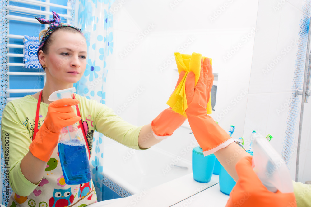 Wall mural Spring cleaning day concept. Hand with rubber glove cleaning mirror