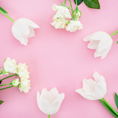 Round frame wreath pattern with roses, white flower buds, branches and leaves isolated on pink background. Flat lay, top view
