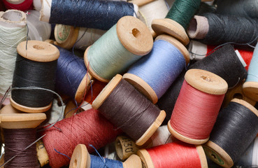 background of plenty multicolor threads bobbins top view. Atelier, sewing accessories backdrop.