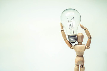 Wood Figure Mannequin holding a light bulb / Business with new idea and motivation concept