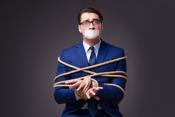 Businessman taken hostage and tied up with rope