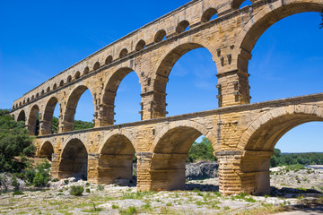 Fototapeta na wymiar Famous In ancient aqueduct Pont du Gard is an old Roman aqueduct in Southern France.