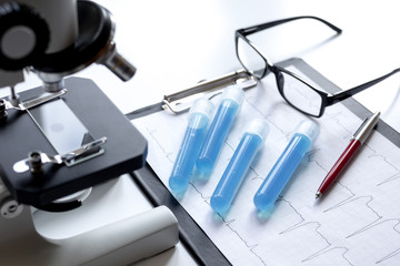 doctors desk with microscope and test tubes