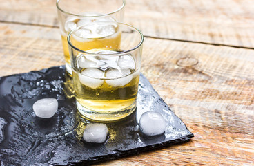 glass of whiskey on wooden background