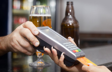 Woman pay with credit card in bar