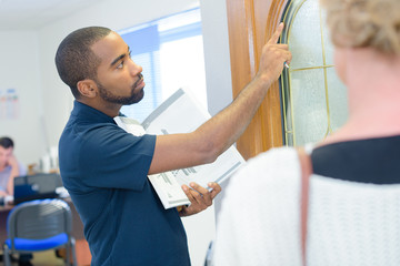 Salesman showing display door to customer