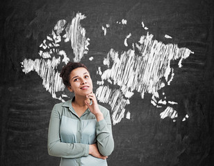 African American girl and world map on blackboard