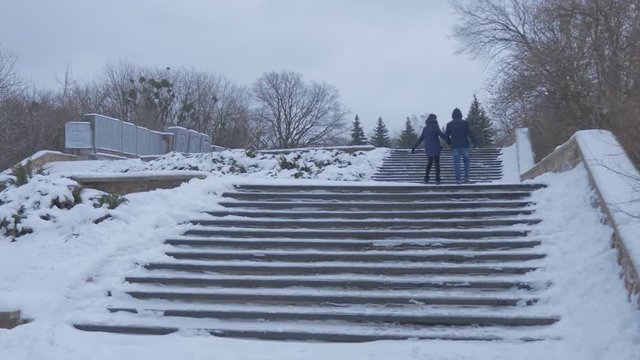 Young People Climbing Stairs at the Observation Platform of Artyom Monument, a Soviet Era Revolutionary Leader, With Bare Trees and a Lot of Snow