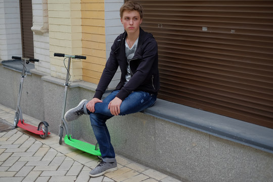portrait of a boy on scooter in urban street