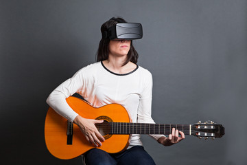 young woman learning how to play the guitar through virtual real