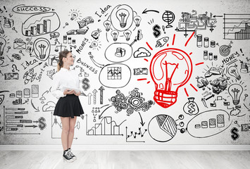 Girl with tablet and idea sketch on concrete