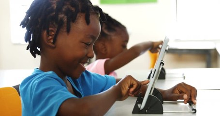Boy using digital tablet in classroom - Powered by Adobe