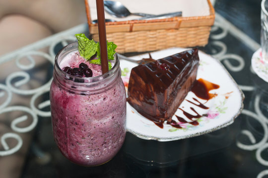 Organic Blueberry Smoothy made with fresh ingredients with chocolate cakes

