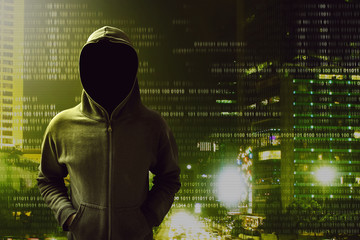 Hacker standing over a screen with binary code