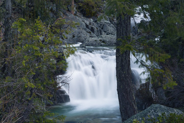 Long exposure of a small waterfall full of spring snowmelt in a granite canyon in the Trinity Alps