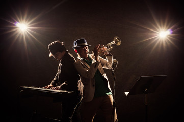 Musician Duo band playing a Trumpet and keyboard on black backgr