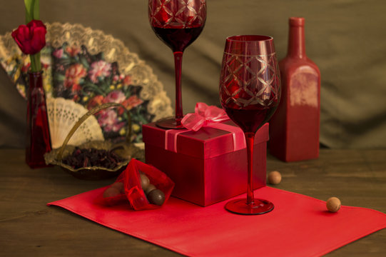 Red gift box with two glasses of wine staged still-life image 