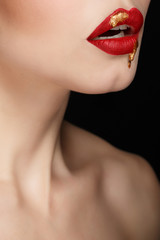 Sensual portrait of a girl with red lips and liquid paint on her face. Makeup simple and catchy. Close-up of sensual female lips. Girl vamp.