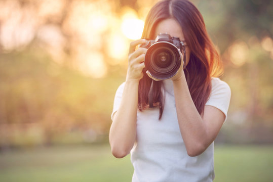 Woman is a professional photographer with dslr camera, outdoor and sunlight, Portrait, copy space.