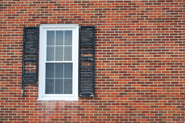 close up on damaged window shutter on brick wall