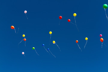 many bright baloons in the blue sky